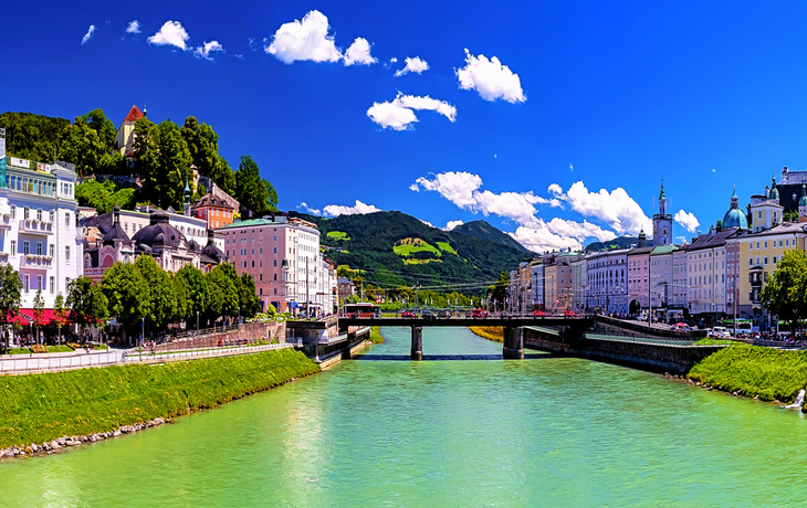 Panorama einer Stadt mit Fluss, Brücke und historischen Gebäuden bei klarem Himmel