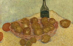 Korb mit Zitronen und Flasche auf einem Tisch.