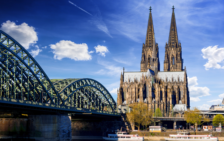 Kölner Dom und Hohenzollernbrücke bei sonnigem Wetter.