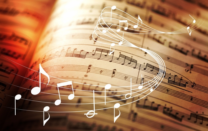Notenblätter mit schwebenden Musiknoten im Vordergrund.