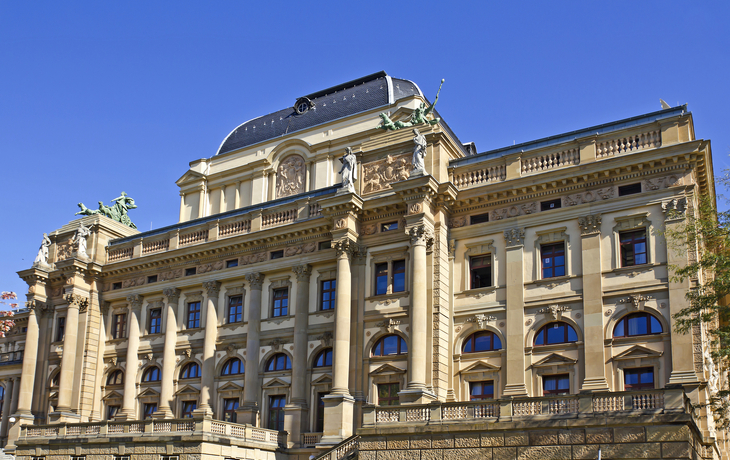 Historisches Gebäude mit neoklassizistischer Fassade und Skulpturen.