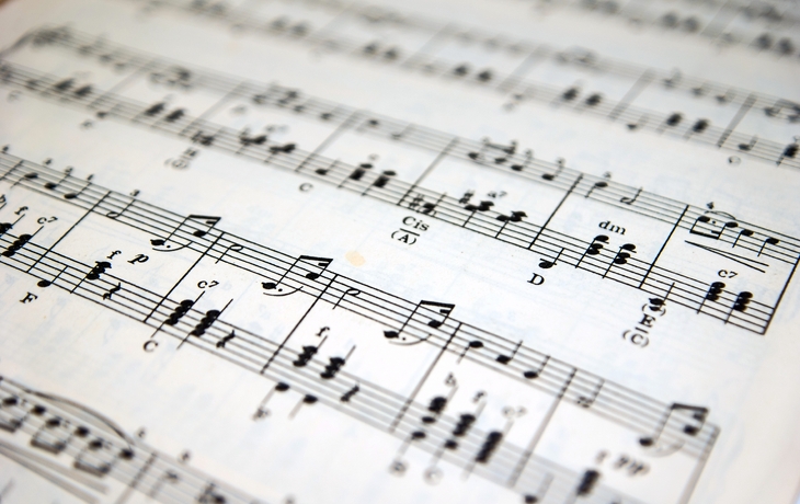 Notenblatt mit Musiknoten auf weißen Hintergrund.