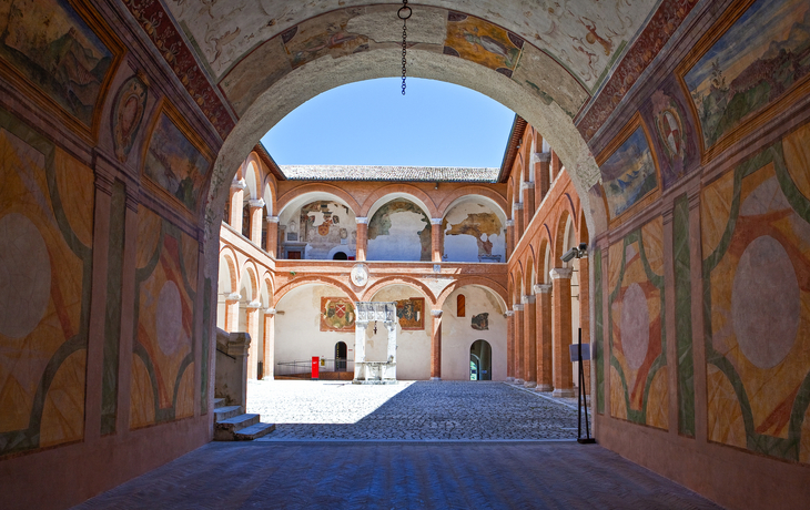 Eine Arkade mit historischen Fresken in einem Innenhof in Spoleto, Italien, Umbrien.