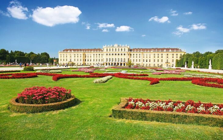Schloss Schönbrunn in Wien mit gepflegten Gärten im Vordergrund.