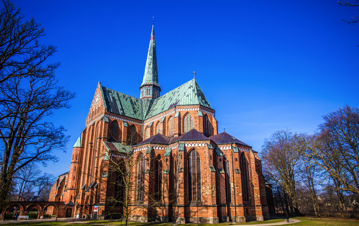 Backsteinkathedrale mit hohem Turm an einem klaren, sonnigen Tag.