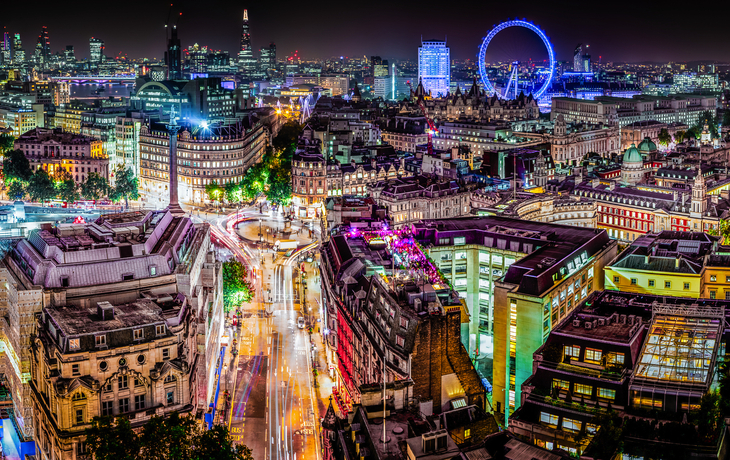 Panorama der Skyline von London bei Nacht mit Blick auf die Themse und beleuchtete Wahrzeichen.