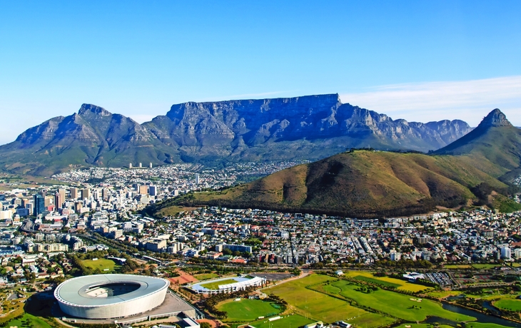 Luftaufnahme von Kapstadt mit Tafelberg und Stadion im Vordergrund.