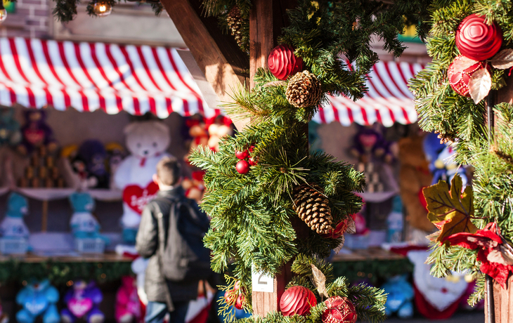 Weihnachtsmarktstand mit Dekorationen und Teddybären im Hintergrund